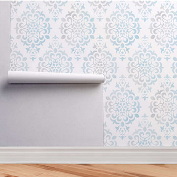 Blue Damask peel and stick wallpaper partially lifted from the wall with the roll edge visible, showing how peel and stick wallpaper comes away