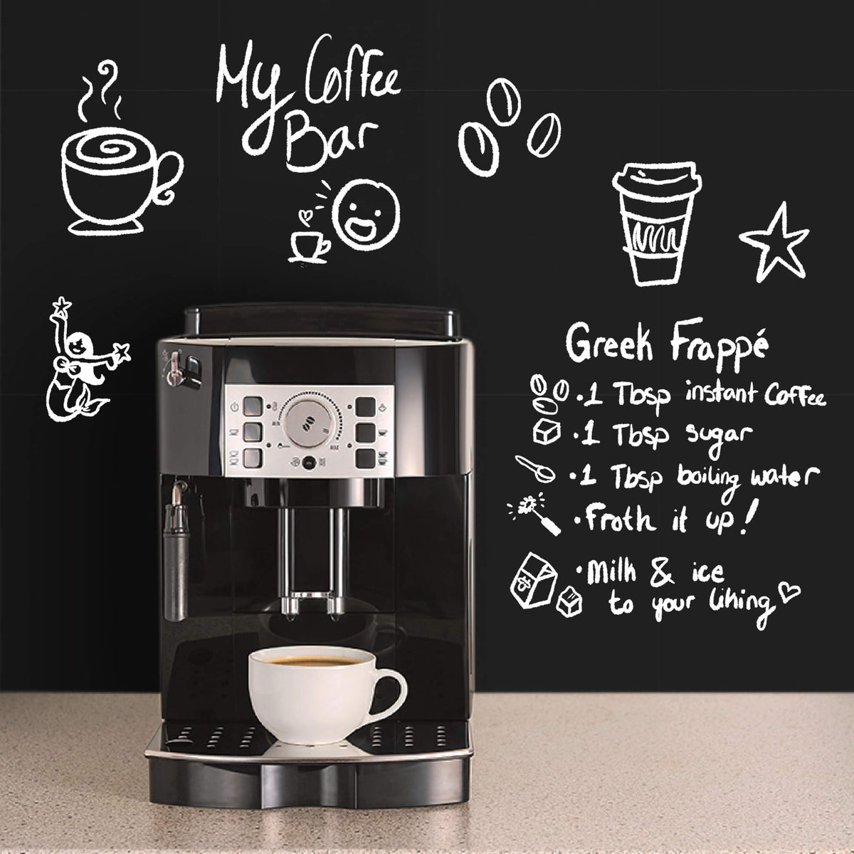 Black chalkboard wall behind a countertop espresso machine and a white coffee cup, with 'My Coffee Bar' and a Greek frappe recipe handwritten in white chalk beside doodles of cups, coffee beans and a star.