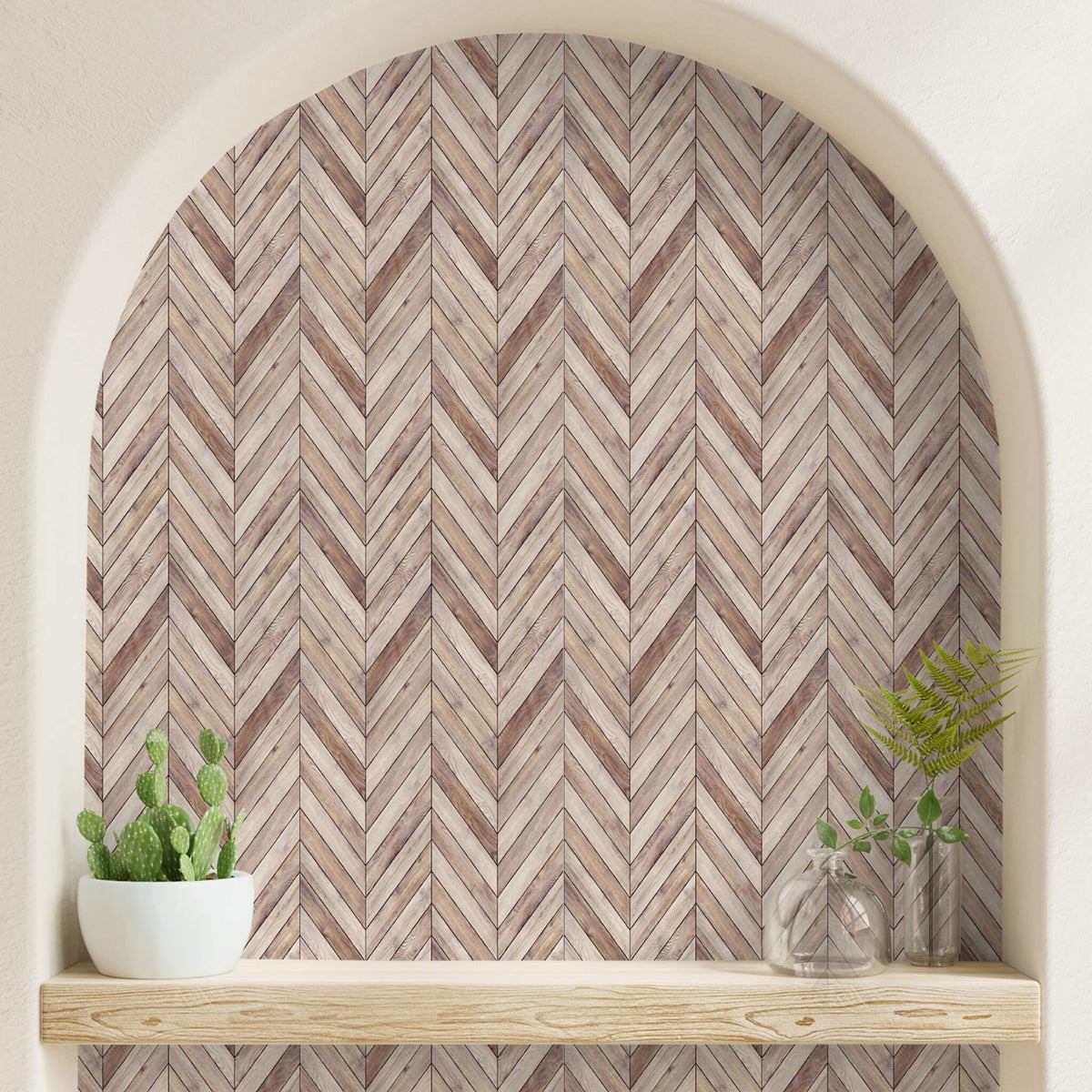Arched wall niche lined with herringbone wood-pattern peel and stick sheets above a natural wood shelf holding plants and glass vases