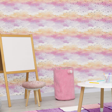 Pastel pink, peach and lilac cloud wallpaper with tiny stars behind a wooden easel, a pink cushioned stool, a pink hamper and a small white play table