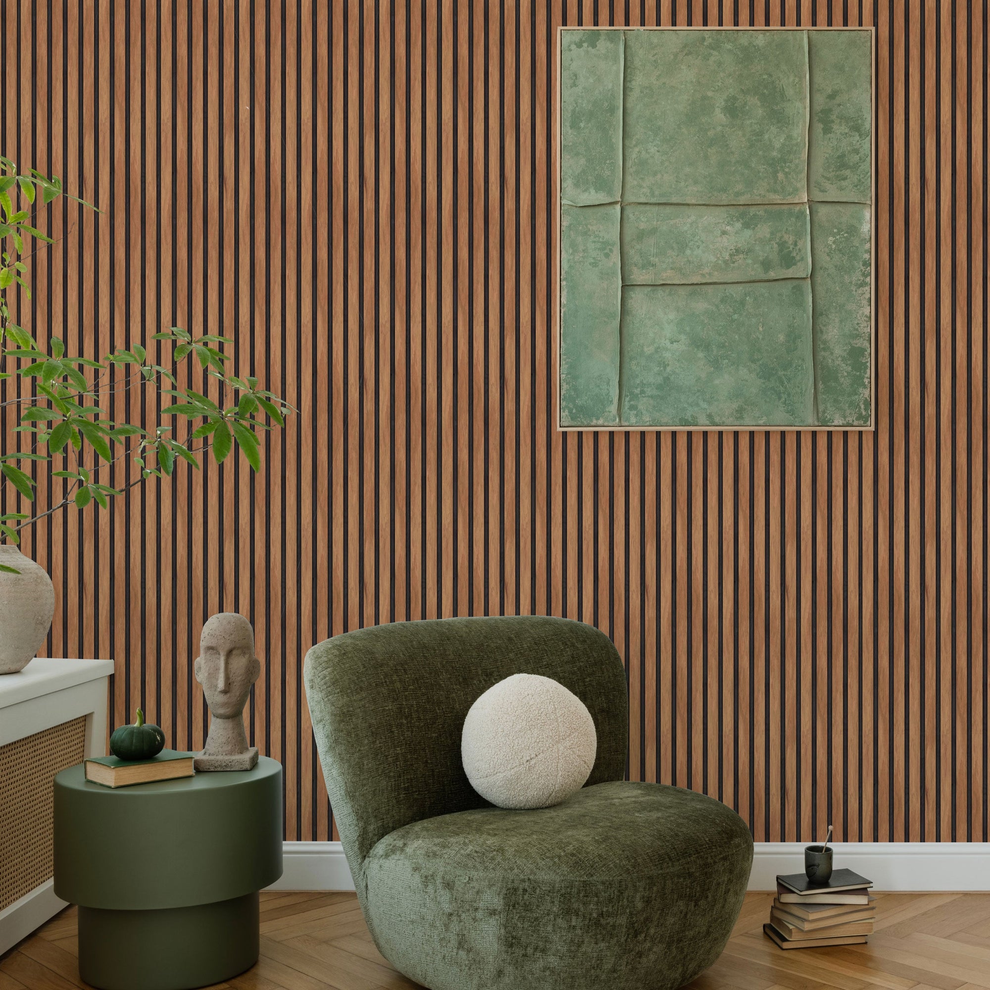 Living room corner with a wall in vertical wood slat look peel and stick wallpaper, a dark green armchair, a round green side table and a framed green abstract artwork above herringbone wood flooring