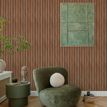 Living room corner with a wall in vertical wood slat look peel and stick wallpaper, a dark green armchair, a round green side table and a framed green abstract artwork above herringbone wood flooring
